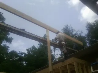 Carpenter setting a ridge beam over a new addition frame — Ice Dam Removal by Roofing Brothers in Bernardston