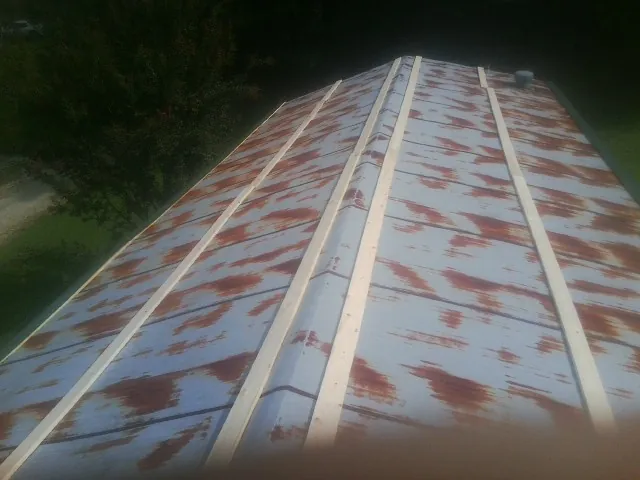Rusted metal roof panels with new wood purlins before replacement — Storm Damage Roof Repair in Bernardston by Roofing Brothers