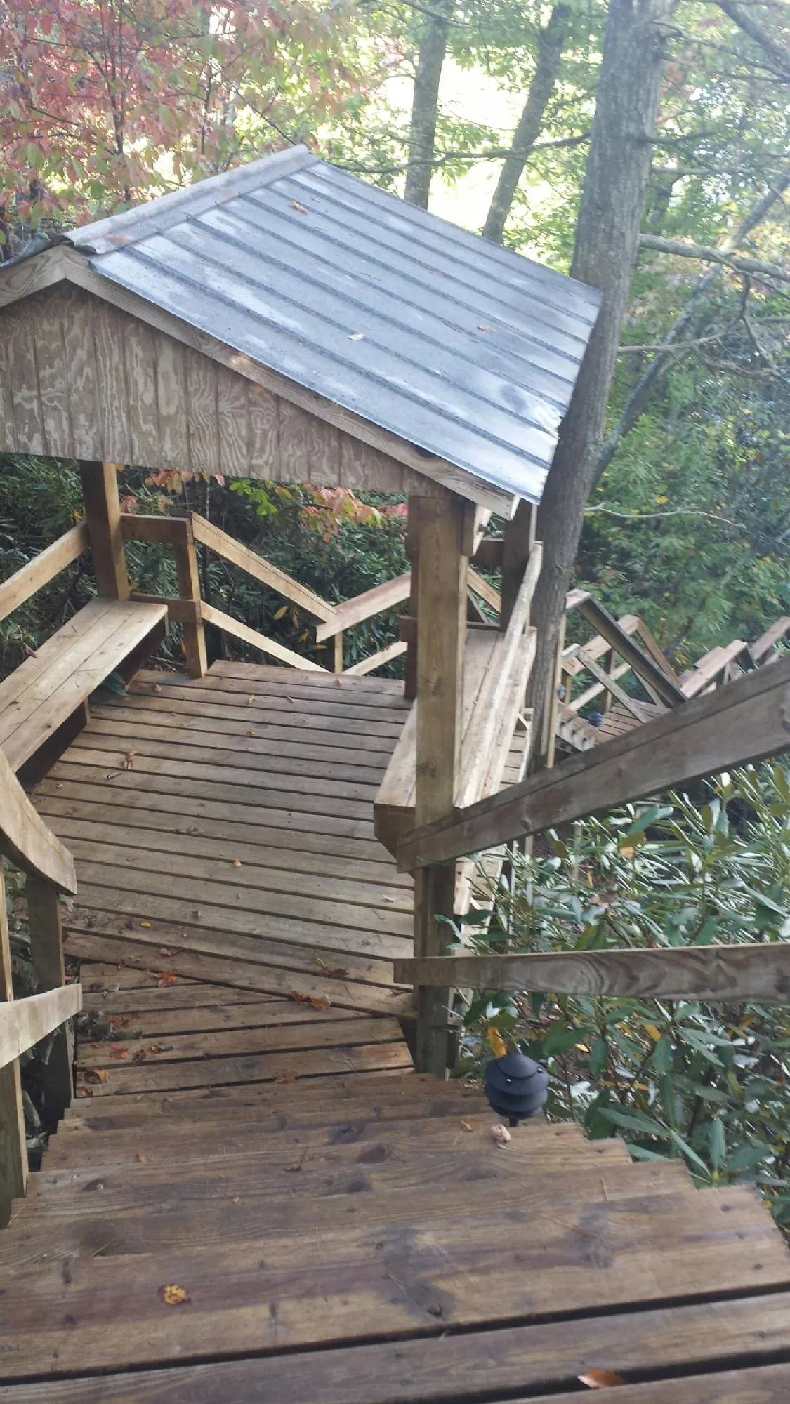 Metal roofed shelter over wooden steps on a wooded walkway — Skylight Repair & Installation work by our crew in Bernardston