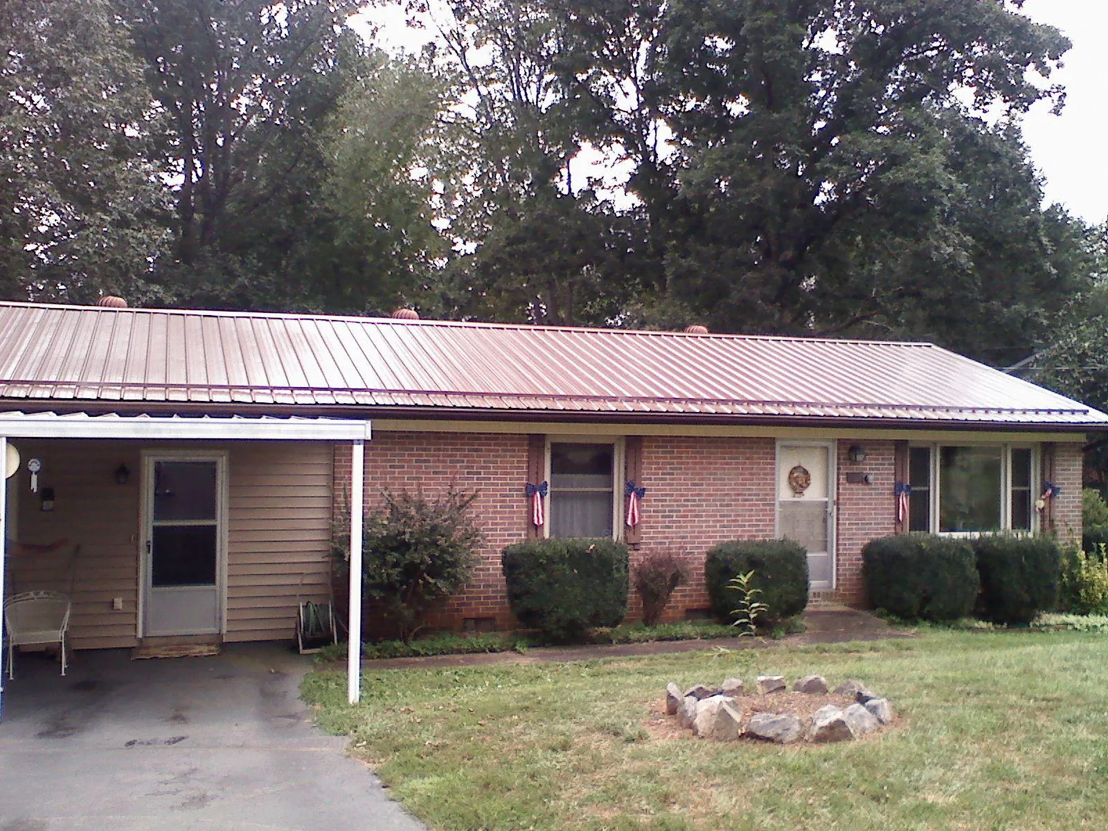 Bronze metal roof and carport on a brick ranch home — Roof Repair work by our crew in Bernardston