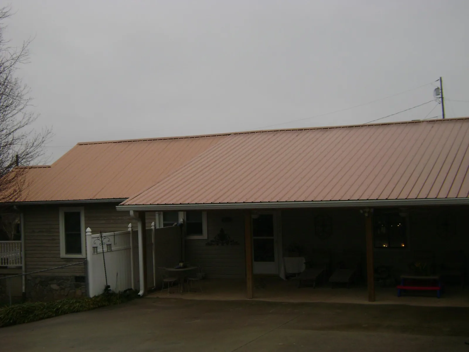 Copper toned metal roof over a wide covered patio in Bernardston